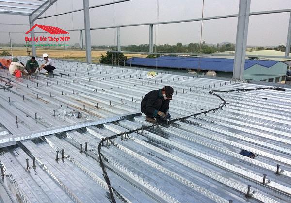 Lắp đặt tôn sàn deck lên dầm thép và cố định bằng đinh hàn 